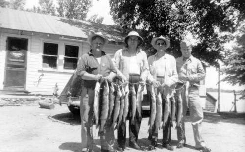 Fisherman with catch at Leach's Resort on Lake Minnewashta. circa 1950