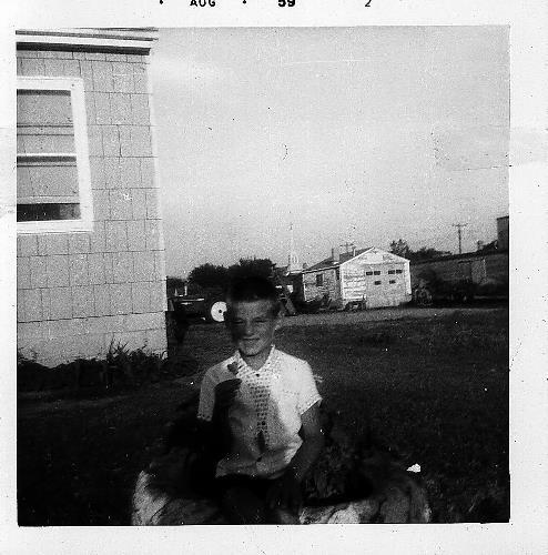 Donald Rettler with a flower at his parent's home on main street - 1959