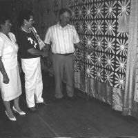 Mr. and Mrs. Claude Lenzmeier and Matheal Schneider with St. Hubert's name quilt.